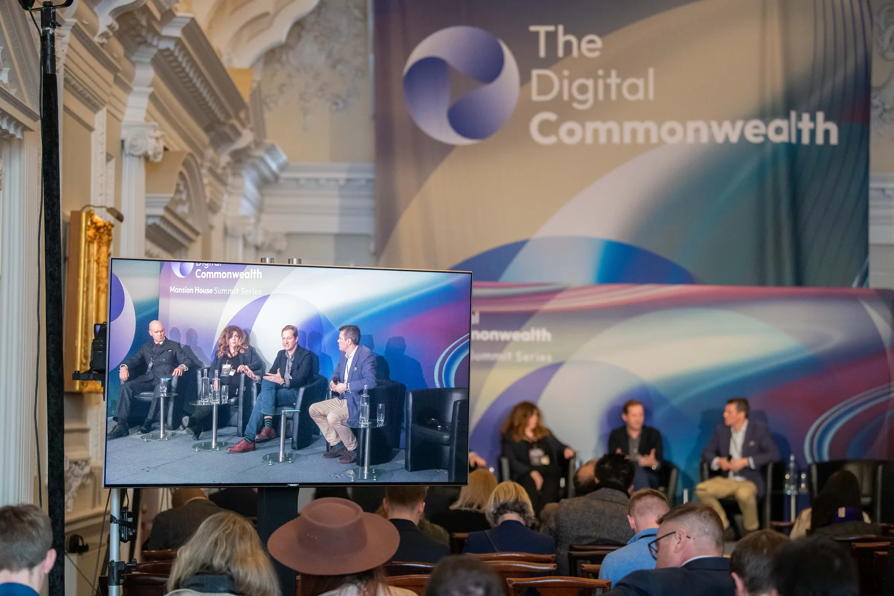 Summit stage and branded backdrop with panel on screen